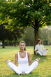 Young couple meditating in park