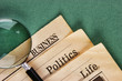 old newspaper and magnifying glass on a green background