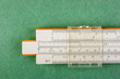 slide rule on a green background