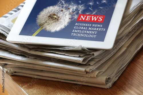 Photo: Digital tablet internet news on paper newspaper Digital tablet internet news on paper newspaper