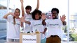 Group of cheerful volunteers raising their arms