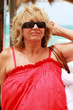 Happy beautiful senior woman on summer vacation at sea