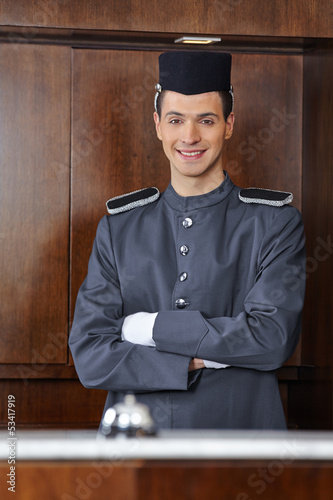 Photo: Concierge im Hotel mit verschränkten Armen Concierge im Hotel mit verschränkten Armen