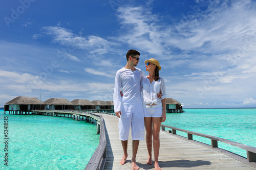Photo: Couple on a beach jetty at Maldives Couple on a beach jetty at Maldives