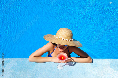 Photo: Woman at poolside with cosmopolitan cocktail Woman at poolside with cosmopolitan cocktail