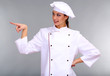 Photo: Portrait of young woman chef on grey background Portrait of young woman chef on grey background