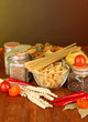 Different types of pasta, spices, tomatoes on a wooden table