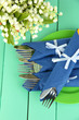 Fork and knife wrapped in blue paper napkin,