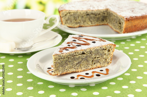 Photo: Delicious poppy seed cake with cup of tea on table close-up Delicious poppy seed cake with cup of tea on table close-up