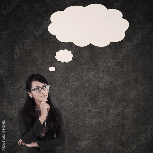 Photo: Businesswoman thinking and cloud copyspace Businesswoman thinking and cloud copyspace
