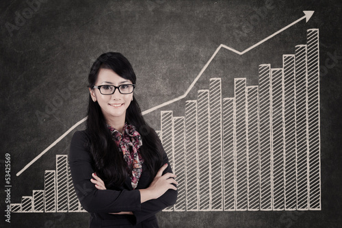 Photo: Businesswoman and growing bar chart Businesswoman and growing bar chart