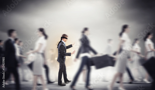 Photo: Businessman in blindfold among group of people Businessman in blindfold among group of people
