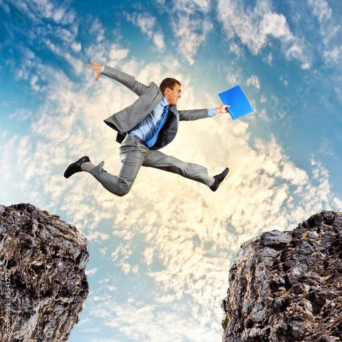 Photo: Businessman jumping over gap Businessman jumping over gap