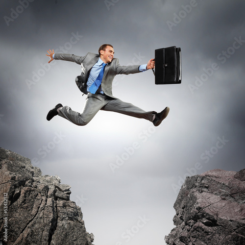 Photo: Businessman jumping over gap Businessman jumping over gap