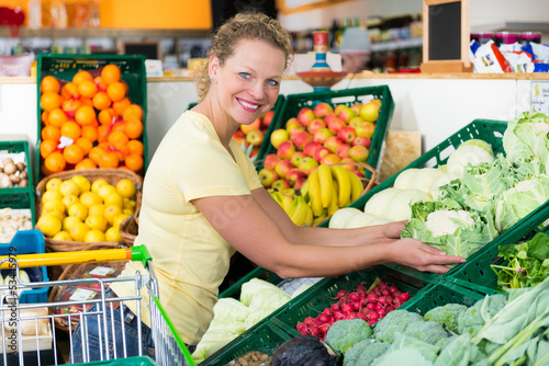 Photo: frau im supermarkt an der gemüsetheke frau im supermarkt an der gemüsetheke