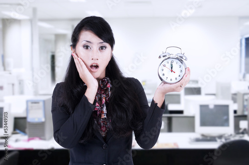 Photo: Beautiful businesswoman shock at deadline clock Beautiful businesswoman shock at deadline clock