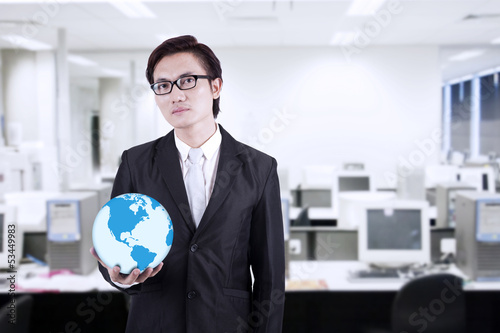 Photo: Businessman hold world globe at office Businessman hold world globe at office