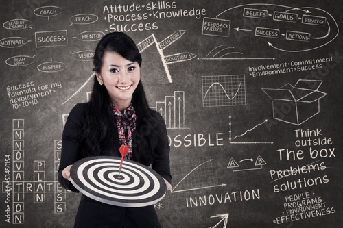 Photo: Businesswoman hold bull's eye in class Businesswoman hold bull's eye in class