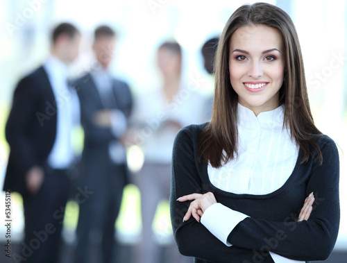Photo: Face of beautiful woman on the background of business people Face of beautiful woman on the background of business people