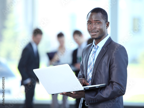 Photo: Confident business man with his team behind Confident business man with his team behind