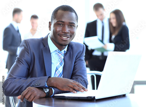 Photo: Portrait of a handsome young business man with a laptop Portrait of a handsome young business man with a laptop