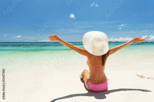 Photo: Beautiful woman sits on the sand Beautiful woman sits on the sand