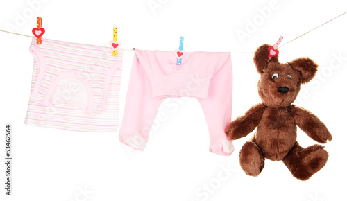 Photo: Baby clothes hanging on clothesline, isolated on white Baby clothes hanging on clothesline, isolated on white