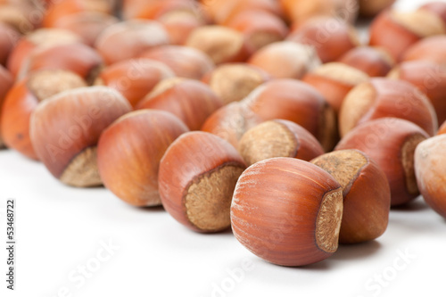 Photo: Unbroken hazelnuts on white surface Unbroken hazelnuts on white surface
