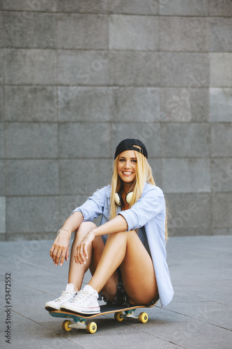 Photo: Young woman sitting on the skater Young woman sitting on the skater