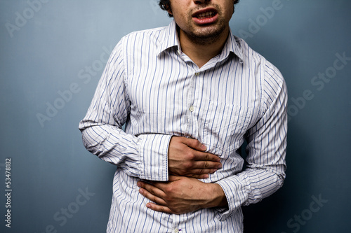 Photo: Multiracial man with stomach pains Multiracial man with stomach pains