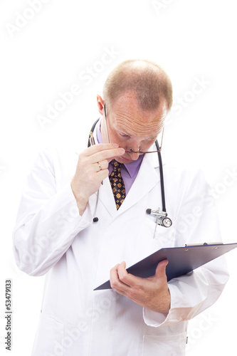 Photo: Stunned medical doctor reading patients file Stunned medical doctor reading patients file