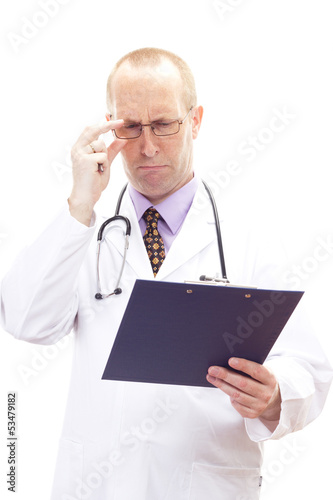 Photo: Male medical physician looking worried on patients record Male medical physician looking worried on patients record