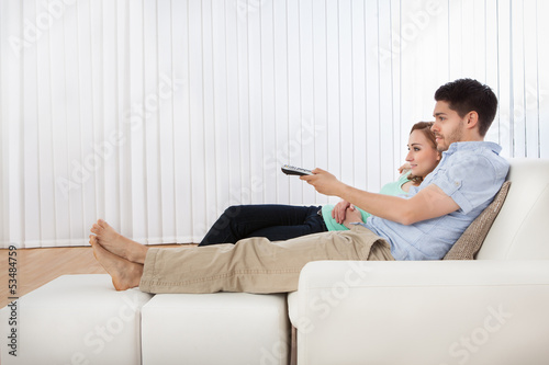 Photo: Young couple watching television Young couple watching television