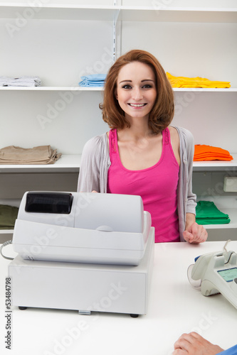 Photo: Young Female Cashier With Cash Register Young Female Cashier With Cash Register