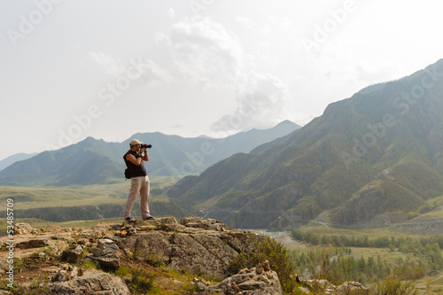 Photo: Beautiful landscape with the silhouette of photographer on backg Beautiful landscape with the silhouette of photographer on backg