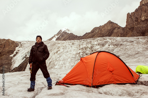 Photo: The climber standing near tent on glacier The climber standing near tent on glacier