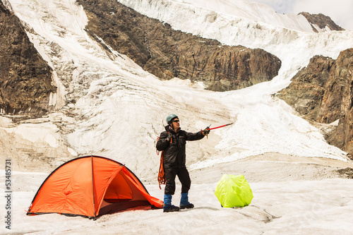 Photo: The climber standing near tent on glacier The climber standing near tent on glacier