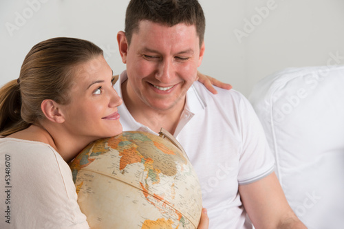 Photo: Portrait of happy romantic couple planning their vacation Portrait of happy romantic couple planning their vacation
