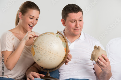 Photo: Portrait of happy romantic couple planning their vacation Portrait of happy romantic couple planning their vacation