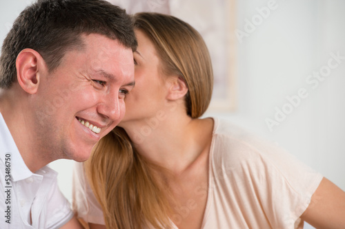 Photo: Happy couple talking and gossiping in their living room Happy couple talking and gossiping in their living room