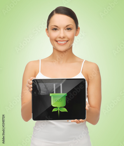 Photo: woman holding tablet pc with green electrical plug woman holding tablet pc with green electrical plug