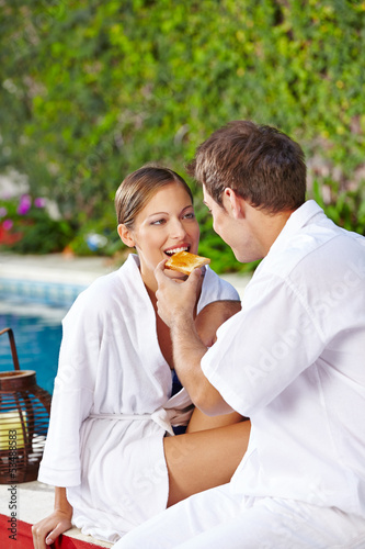 Photo: Couple having breakfast at pool Couple having breakfast at pool