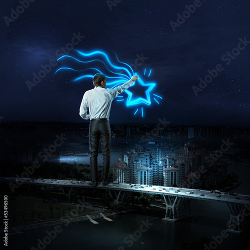 Photo: Businessman draws a glowing signs Businessman draws a glowing signs