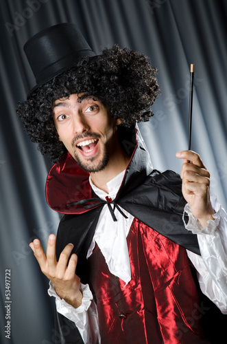 Photo: Magician in the dark room with wand Magician in the dark room with wand