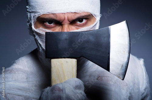 Photo: Mummy with axe in halloween concept Mummy with axe in halloween concept