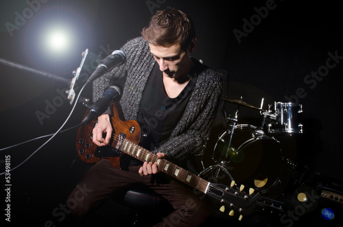 Photo: Man playing guitar during concert Man playing guitar during concert