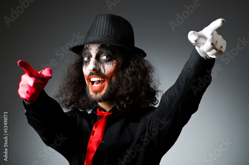 Photo: Joker personification with man in dark room Joker personification with man in dark room