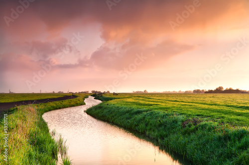 Photo: dramatic sunrise over canal in farmland dramatic sunrise over canal in farmland