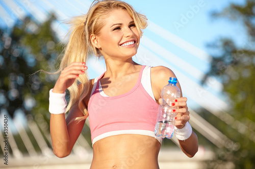 Photo: woman during fitness on city is listen to the music woman during fitness on city is listen to the music