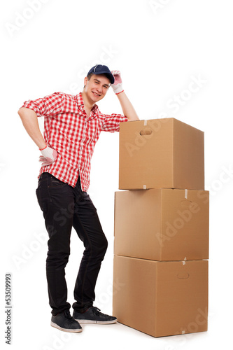 Photo: Handsome young courier with brown boxes Handsome young courier with brown boxes